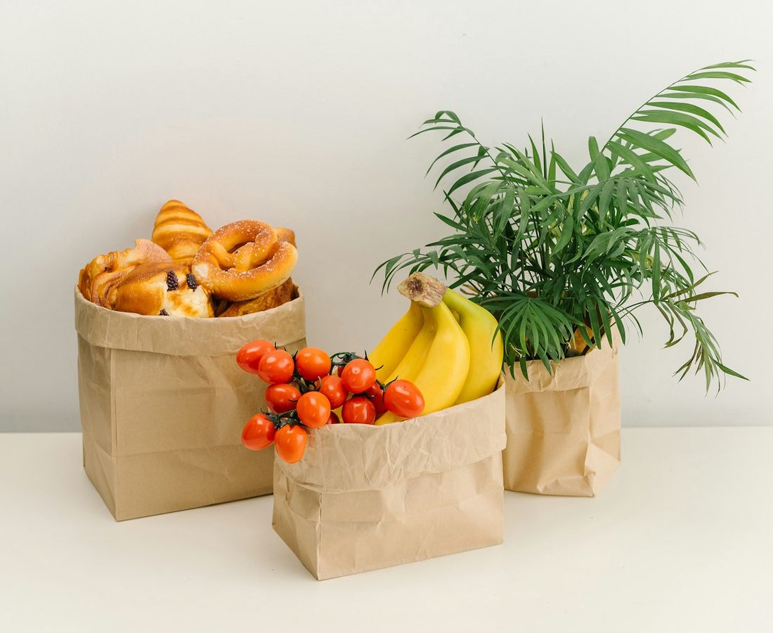 Sacolas de papel com pães, frutas e verduras